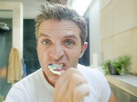 Man brushes teeth