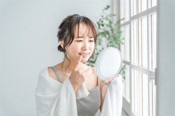 Woman pulling lip down to reveal red, swollen gums
