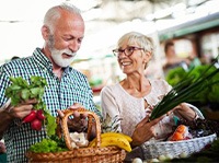 Senior couple smiling while shopping for produce