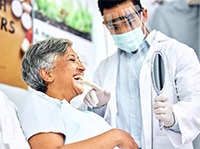 Dentist pointing to smiling patient's teeth